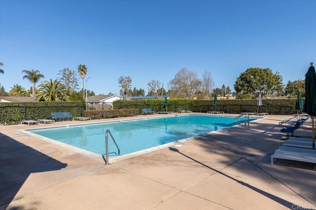 pool with a patio area and fence