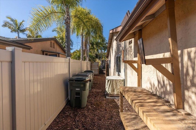 view of side of property featuring stucco siding and fence