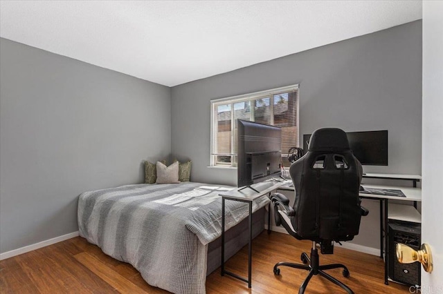 bedroom featuring baseboards and wood finished floors