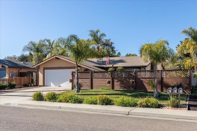 view of front of property featuring stucco siding, a front lawn, driveway, fence, and a garage