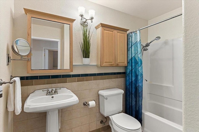 bathroom featuring toilet, tile walls, and shower / bath combo