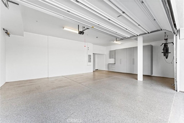 garage with electric panel and a garage door opener