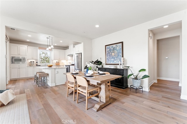 dining space with recessed lighting, baseboards, and light wood-style flooring