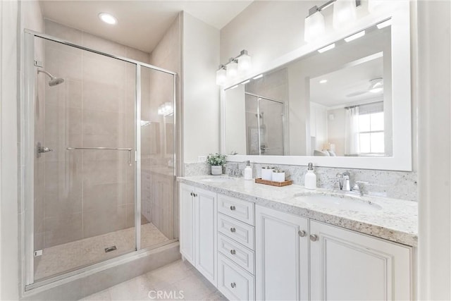 bathroom with a shower stall, tile patterned floors, and a sink