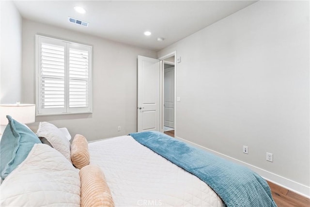 bedroom with recessed lighting, wood finished floors, visible vents, and baseboards