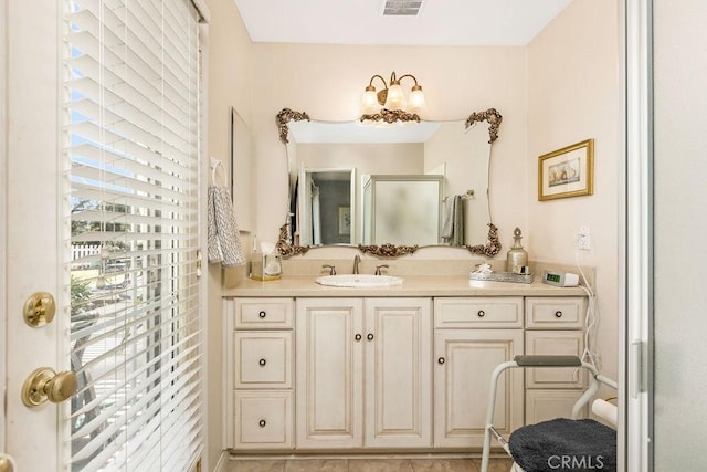 bathroom with visible vents, a shower stall, and vanity