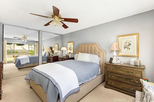 carpeted bedroom featuring a ceiling fan and a textured ceiling