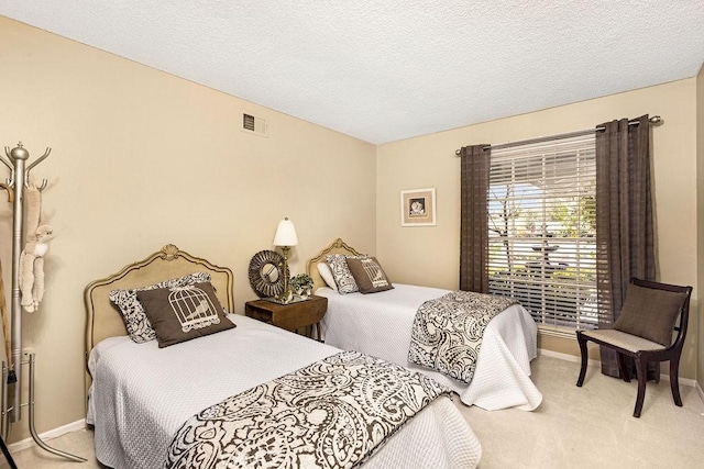 bedroom featuring visible vents, baseboards, carpet, and a textured ceiling