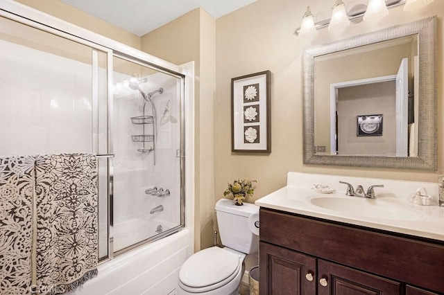 full bath with vanity, toilet, and bath / shower combo with glass door