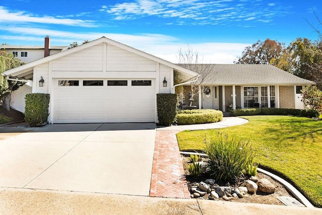 view of front of home featuring concrete driveway, a front lawn, and a garage