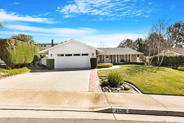 view of front of home featuring an attached garage, concrete driveway, and a front lawn