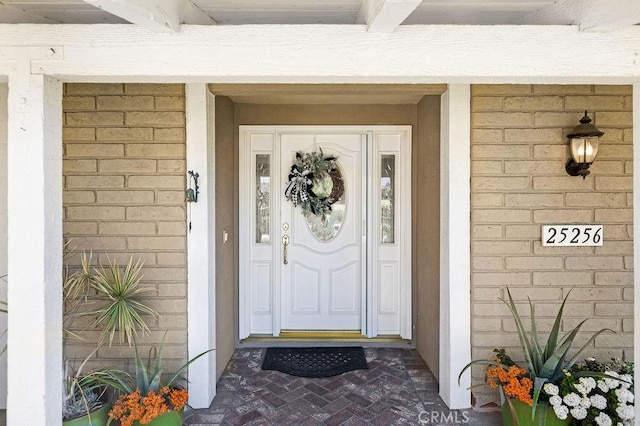 view of exterior entry featuring brick siding