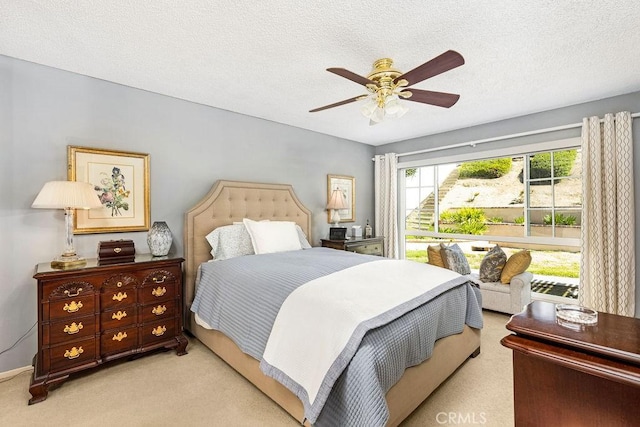 carpeted bedroom with ceiling fan and a textured ceiling