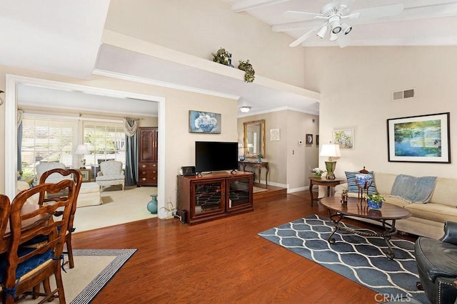 living area with wood finished floors, visible vents, baseboards, ceiling fan, and beamed ceiling