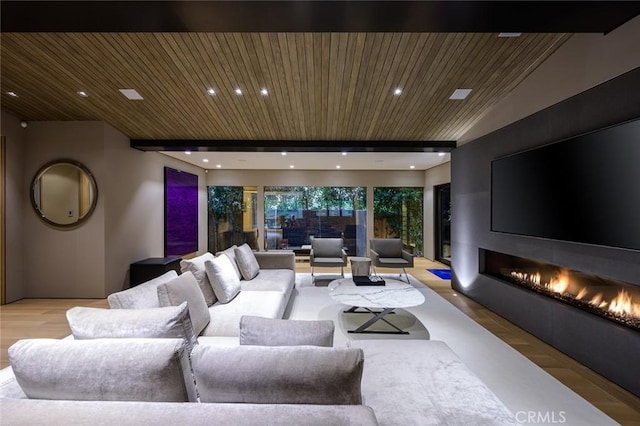 living room with wood finished floors, vaulted ceiling with beams, recessed lighting, and a large fireplace