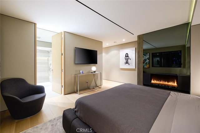 bedroom featuring recessed lighting and a warm lit fireplace