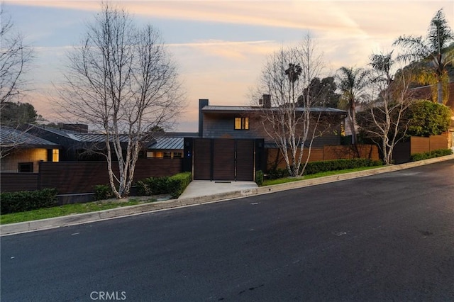 view of front of home with a chimney, metal roof, and fence