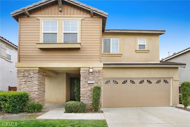 traditional-style house featuring stone siding, stucco siding, concrete driveway, and a garage