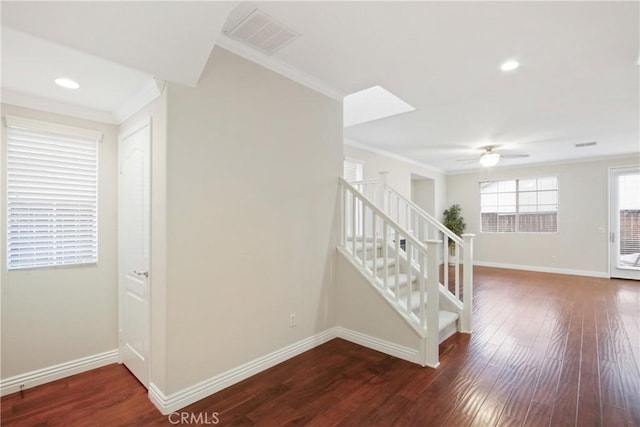 interior space featuring dark wood finished floors, crown molding, baseboards, and visible vents