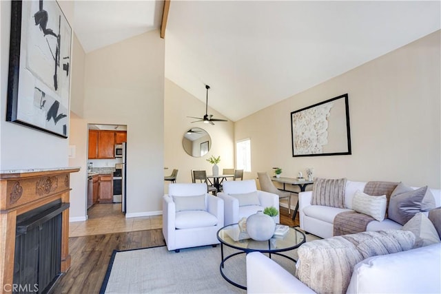 living room featuring beam ceiling, dark wood-style floors, a fireplace, baseboards, and ceiling fan