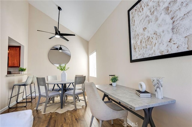 dining area with ceiling fan, high vaulted ceiling, baseboards, and wood finished floors