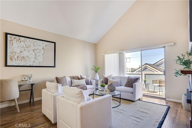 living area with wood finished floors, baseboards, and high vaulted ceiling