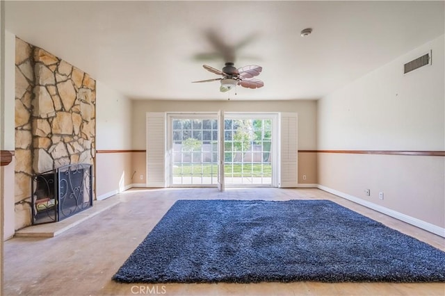 unfurnished living room with visible vents, baseboards, a fireplace, and a ceiling fan