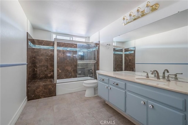 bathroom with vanity, toilet, and shower / bath combination with glass door