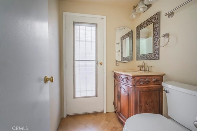 half bath with tile patterned flooring, toilet, and vanity