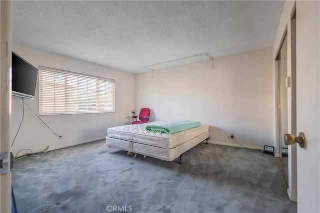 carpeted bedroom with a textured ceiling and attic access