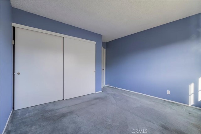 unfurnished bedroom with a closet, carpet flooring, and a textured ceiling