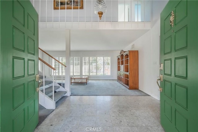 carpeted foyer entrance featuring tile patterned floors and stairway