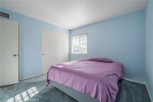 carpeted bedroom featuring visible vents and a closet