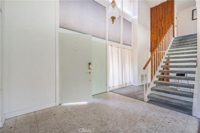 entryway featuring tile patterned floors, stairway, and visible vents