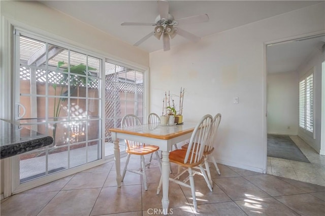 dining space featuring tile patterned floors, baseboards, and a ceiling fan