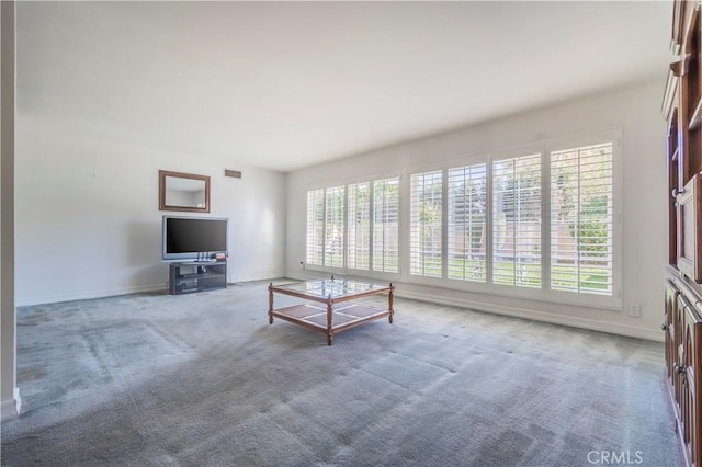 unfurnished living room with visible vents, baseboards, and carpet