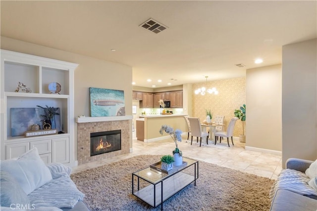 living room featuring visible vents, baseboards, a tiled fireplace, built in features, and recessed lighting