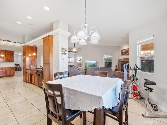 dining room featuring recessed lighting, light tile patterned flooring, a fireplace, and ceiling fan with notable chandelier