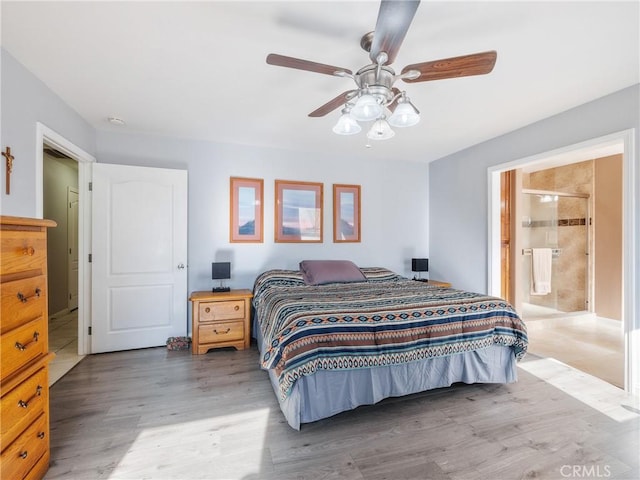 bedroom with wood finished floors, ensuite bathroom, and ceiling fan