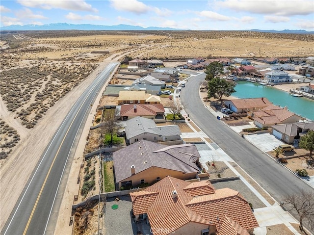 birds eye view of property featuring a residential view, view of desert, and a water and mountain view