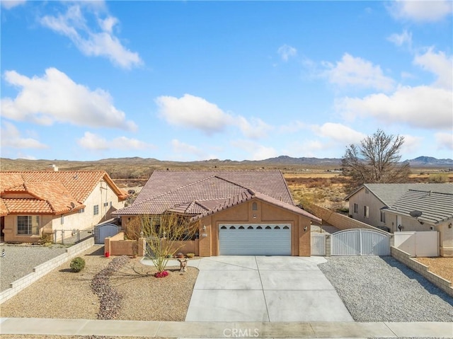 view of front of home featuring a gate, fence, a garage, a tile roof, and a mountain view