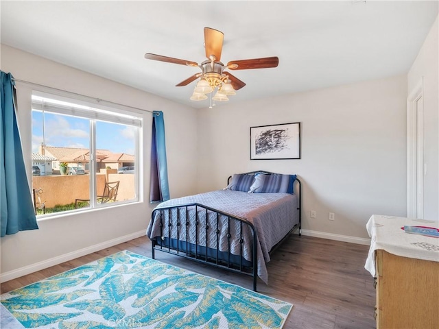 bedroom with wood finished floors, baseboards, and ceiling fan