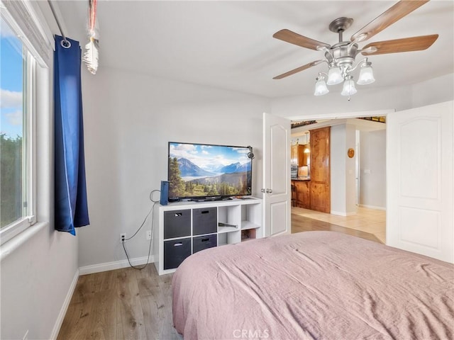 bedroom with baseboards, light wood-style floors, and a ceiling fan