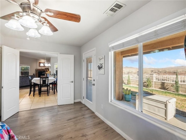 foyer entrance featuring ceiling fan, wood finished floors, visible vents, and baseboards