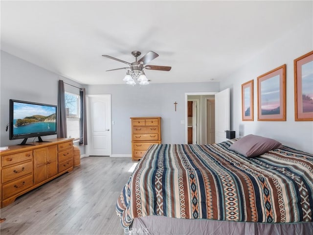 bedroom featuring baseboards, light wood-style flooring, and a ceiling fan