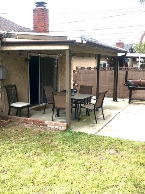 view of patio / terrace with outdoor dining space, a grill, and fence