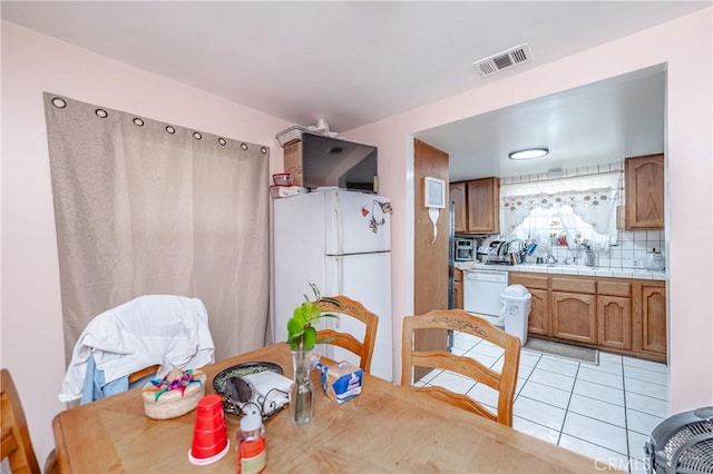 dining space with light tile patterned floors and visible vents