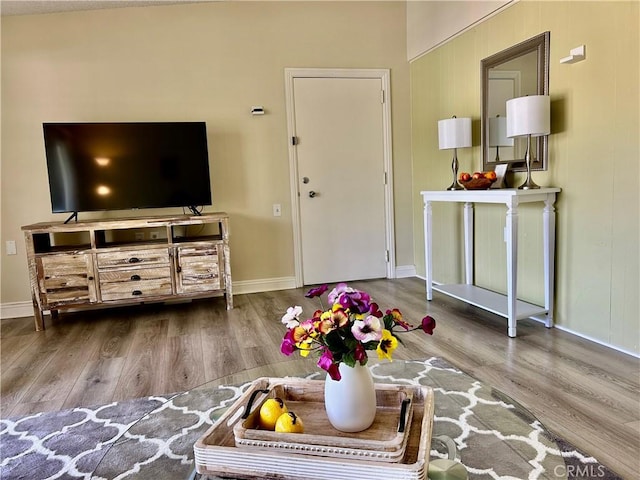 living area with baseboards and wood finished floors