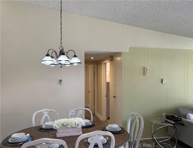 dining space featuring lofted ceiling, a textured ceiling, and an inviting chandelier