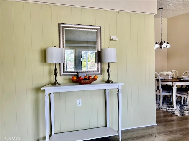 details featuring a notable chandelier, a textured ceiling, and wood finished floors